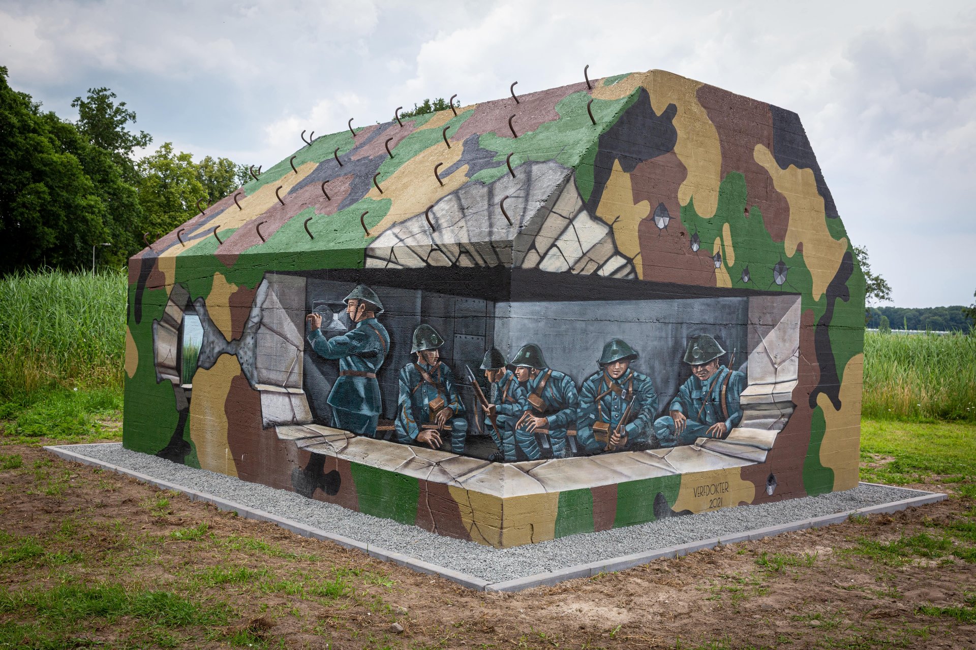 beschilderde groepsschuilplaats. Op de groepsschuilplaats zijn soldaten in de bunker afgebeeld, de bunker is beschilderd met legerprint